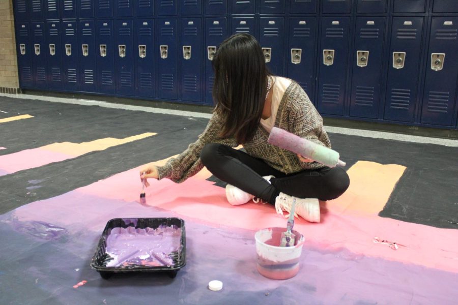 Photo taken by Juhi Godbole. Student Council member painting homecoming banner from October 2022. 