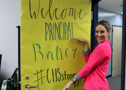 Baker poses outside the door to her office, wrapped in a welcoming decorative sign. 