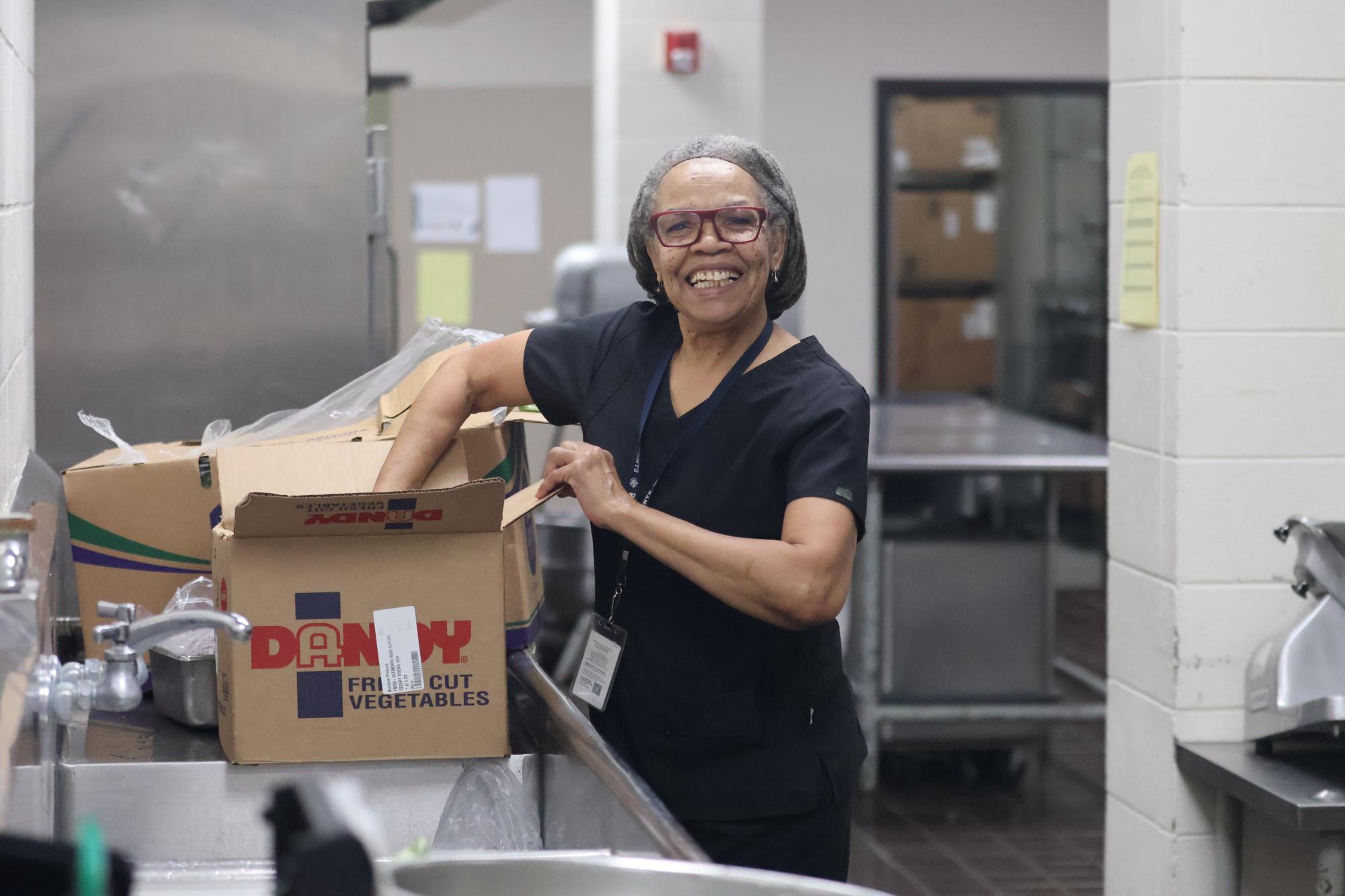 Maureen Palm unpacks a box of vegetables for the chicken fajita salad, which is served daily. 