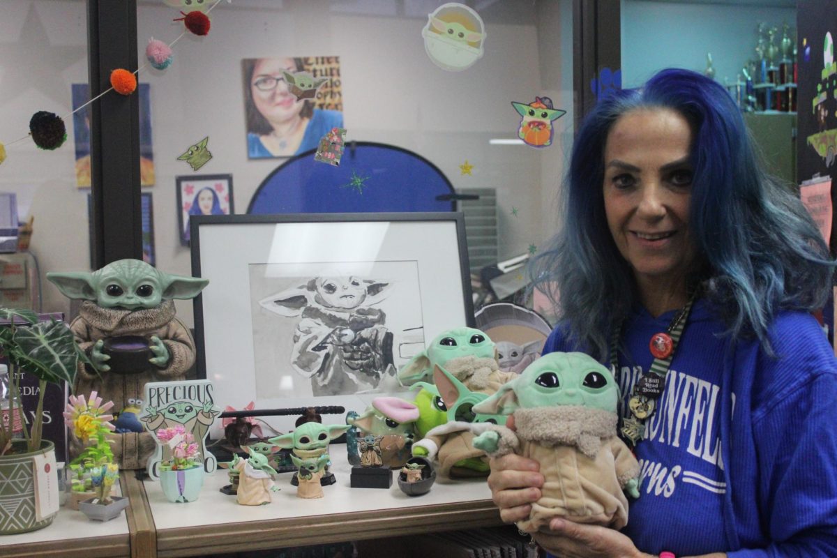 Librarian Marion Brennan beside her Baby Yoda collection.